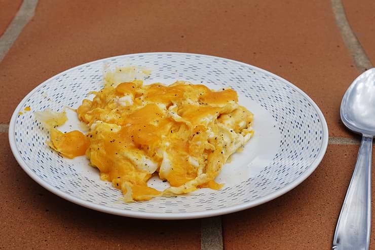 Leckeres Rührei mit Käse als Low Carb Frühstück auf Teller.